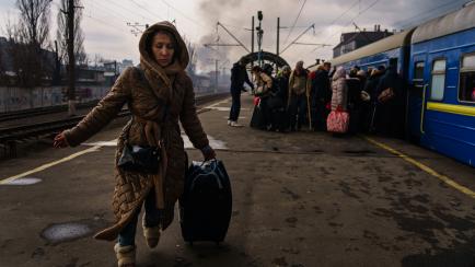 Una mujer corriendo en una estación de trenes para evacuar a refugiados y desplazados ucranianos por la invasión rusa, en Irpín.