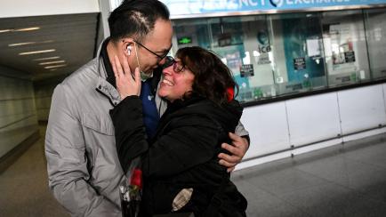 Un pareja se abraza en un aeropuerto de China.