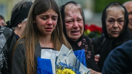 Unos familiares de un soldado muertos lloran en el homenaje a los caídos