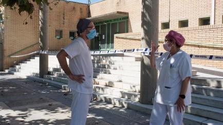 Dos sanitarios conversan a la salida del hospital de Fraga (Huesca), donde están aislados varios pacientes de coronavirus.