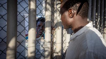 Un migrante pasa por delante de un centro temporal para extranjeros el 25 de junio de 2022 en Melilla, un día después de que al menos 23 personas murieran en un salto a la valla.