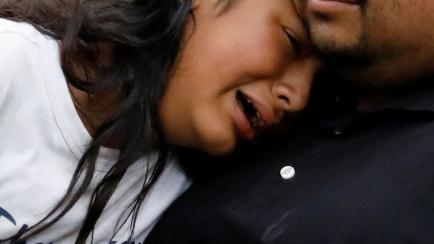 Dos personas lloran tras la matanza en el colegio