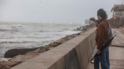 Un hombre haciendo una fotografía frente al mar.