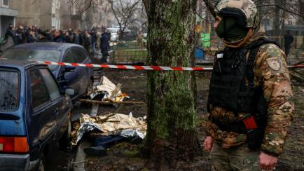 Un militar hace guardia cerca de los cadáveres donde un helicóptero ha caído sobre varios edificios a las afueras de Kiev, este miércoles.