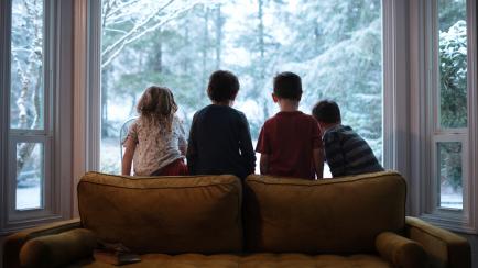 Imagen de archivo de varios niños en un salón con calefacción, en pleno invierno.