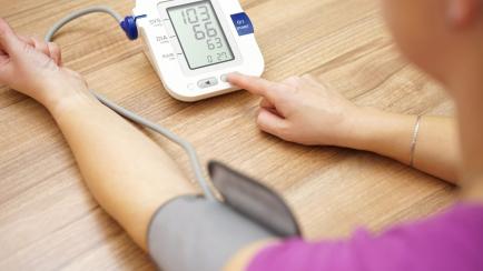 Una persona mide su presión arterial