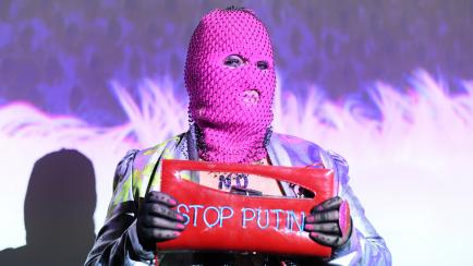 Una componente de Pussy Riot, con un bolso en el que se lee "Stop Putin".