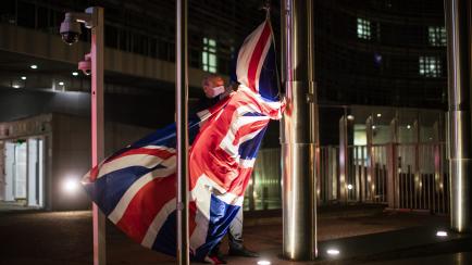 Un trabajador de la Comisión Europea retira la bandera de Reino Unido del edificio Berlaymont, en Bruselas, ante la entrada en vigor del Brexit.