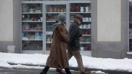 Una pareja camina por una calle cubierta de nieve en Lugo.