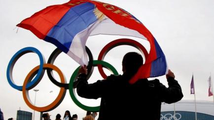 Un aficionado ondea una bandera rusa frente al logo olímpico