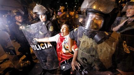 Policías detienen en Lima a una mujer que protesta contra el Gobierno de Dina Boluarte.