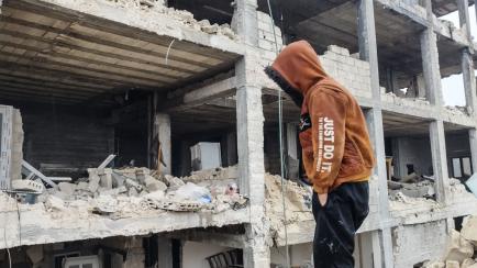 Un joven observa un edificio destrozado por el terremoto
