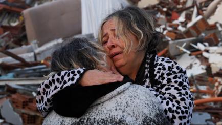 Unas mujeres se abrazan desesperadas en mitad de la destrucción del terremoto en Hatay, Turquía, ayer.