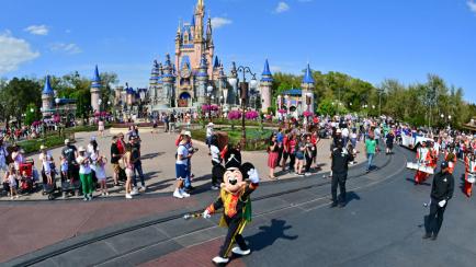 Mickey Mouse saluda a cámara durante un desfile en Disney World Orlando.