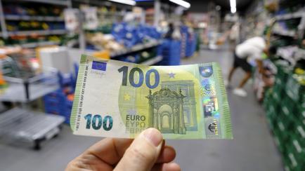 Una persona con un billete de 100 euros