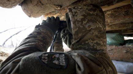 Un soldado de infantería ucraniano observa las posiciones rusas desde una trinchera de primera línea frente en Bajmut.