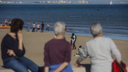 Foto de archivo de varias personas disfrutando del sol en una playa de Valencia.