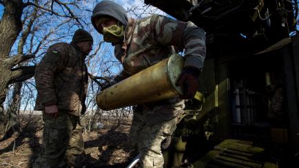 Dos soldados ucranianos cargando una batería de artillería 2S5 Giatsint-S, en el frente de Bajmut (Donetsk).