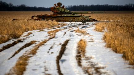 Un tanque ruso destruido en un campo de trigo cubierto de nieve en Ucrania.