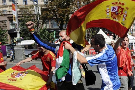 Dos aficionados italianos animan a su selección junto a otros dos aficionados españoles en las calles de Kiev.