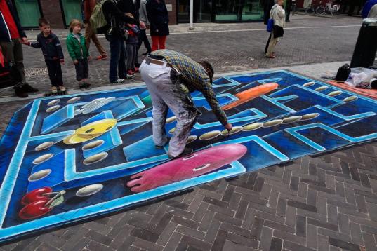 Leon Keer pintando su Pac-Man en una de las calles de la ciudad de Venlo