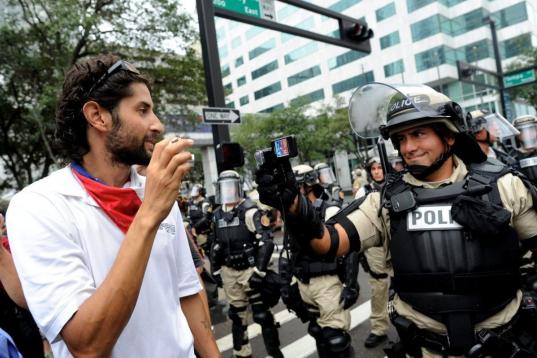 Un manifestante y un policía se graban en video mutuamente
