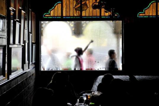  Manifestantes pasan frente a una ventana de un restaurante donde un grupo de líderes republicanos está reunido 
