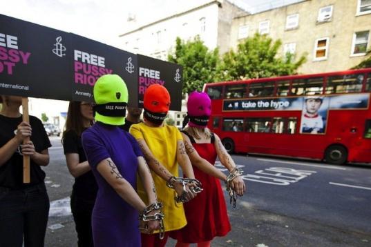 n grupo de simpatizantes de las 'Pussy Riot' con pasamontañas fluorescentes, pañuelos en la boca y las manos encadenadas, realizan una protesta frente a la embajada rusa para entregar una petición con 10.000 firmas en apoyo al grupo de punk r...