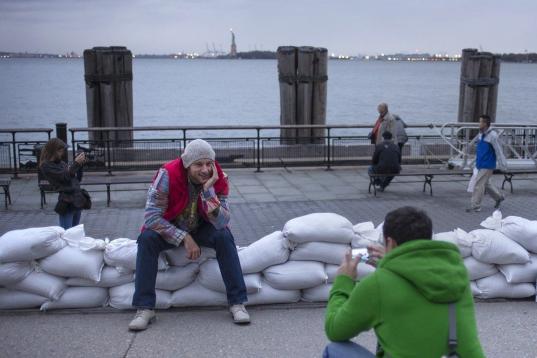 Turistas rusos en Battery Park (Lower Manhattan) este domingo. Se hacen fotos sobre un pequeño dique de sacos de arena.