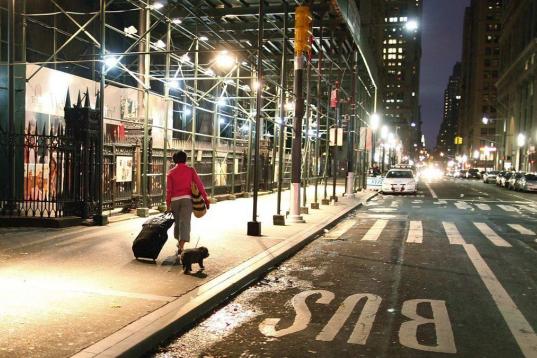Una mujer, con su maleta, rumbo a la estación de Wall Street para abandonar la ciudad ante la alerta por Sandy.