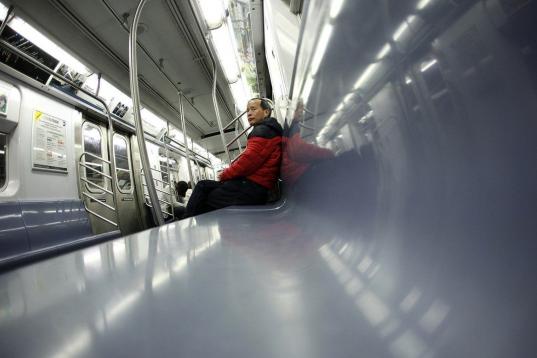 Un pasajero, en el tren número cuatro en Manhattan, Nueva York, viajando hacia el norte. Tiene el vagón para él solo, ya que miles de personas prefieren permanecer en sus casas, atrincherados por lo que pueda pasar