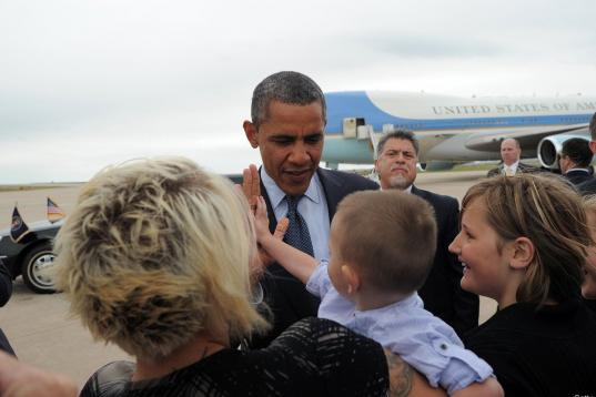 Obama saluda a un niño después de descender el avión presidencial para asistir a uno de los actos de apoyo para su reelección.