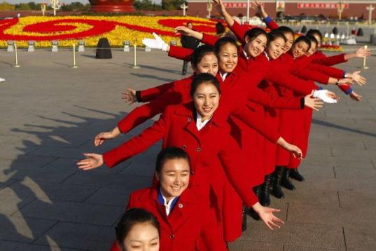 Un grupo de azafatas posan para el fotógrafo frente al Gran Palacio del Pueblo, antes de la celebración de la ceremonia de apertura del Congreso del Partido Comunista de China
