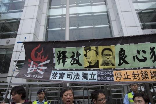 Activistas prodemocráticos rompen fotos del XVIII Congreso del Partido Comunista de China mientras protestas en los alrededores de la Delegación del Gobierno chino en Hong Kong