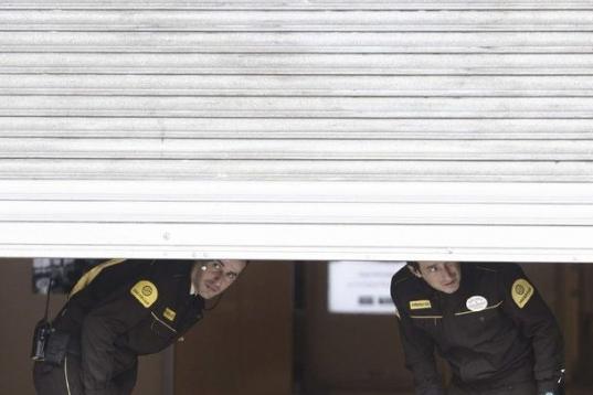 Agentes privados de seguridad miran hacia la calle desde el interior de una empresa, en el centro comercial Triangle de plaza Catalunya, en Barcelona.