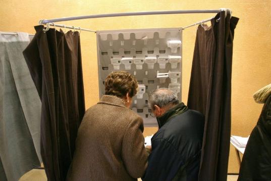 Dos personas preparan sus papeletas esta mañana en un colegio electoral en Tarragona.