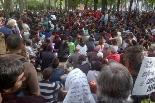 Un grupo de personas sentadas en el Paseo del Prado, antes de la manifestación