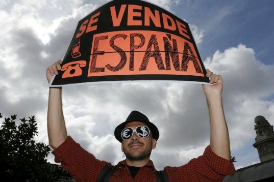 Un manifestante porta una pancarta que reza: "Se vende España"