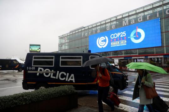 Vehículos policiales que forman parte del dispositivo de seguridad son estacionados en una de las entradas a la Cumbre del Clima que arranca este lunes en Madrid.