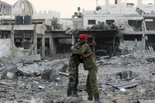Dos oficiales de Hamás celebran entre los escombros el alto el fuego en la zona