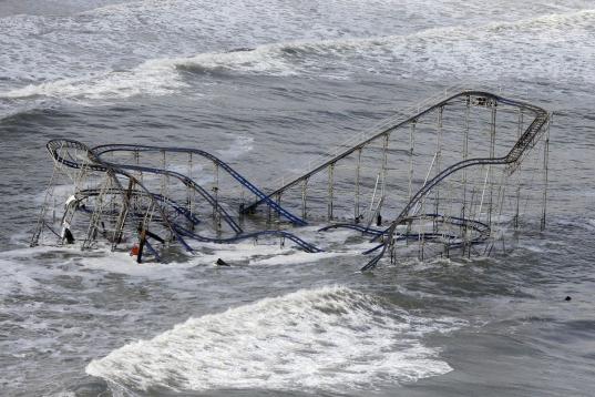 En esta foto del 31 de octubre del 2012 las olas azotan la montaña rusa de un parque de diversiones de Seaside Heights, Nueva Jersey, a causa de la supertormenta Sandy. Aunque puede ser engañoso vincular un solo episodio meteorológico con el ...