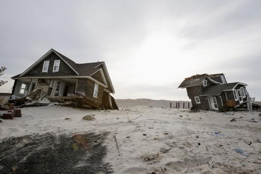 En esta foto de archivo del 22 de febrero del 2013 se ven dos viviendas destruidas en la playa de Mantoloking, Nueva Jersey, por la supertormenta Sandy. El calentamiento global pudiera reducir las probabilidades de las inusuales corrientes atmos...