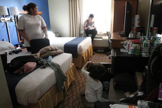 Raquel Rivera, a la izquierda, habla con su prometido Seth Muñoz Irizarryz, mientras su hija Marisol abre la nevera en la habitación del hotel Holiday Inn Express de Nueva York, el 25 de abril del 2013. Rivera perdió el apartamento en el que ...
