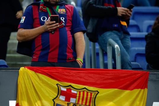 Un aficionado del Barça, junto a una bandera de España con el escudo culé