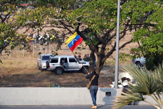Un hombre ondea la bandera venezolana. 
