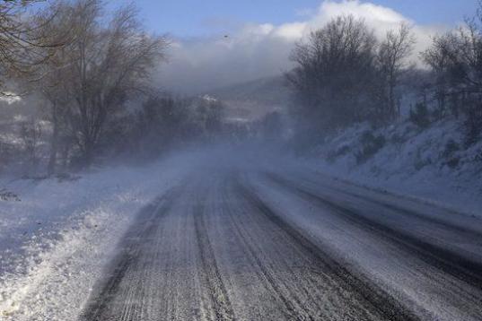 En la imagen, el viento levanta la nieve en la carretera de Guadarrama, en la sierra madrileña. El temporal ha obligado a cerrar algunos puertos de montaña y ha dificultado el tránsito por carreteras de la red secundaria de Asturias, Cantabri...