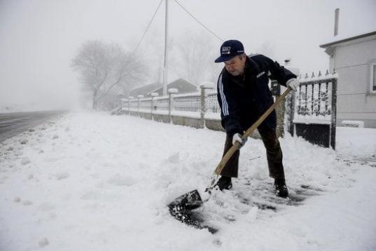 Un hombre retira la nieve con una pala en la entrada de su casa en la localidad orensana de Casetas de Rodicio (Maceda).