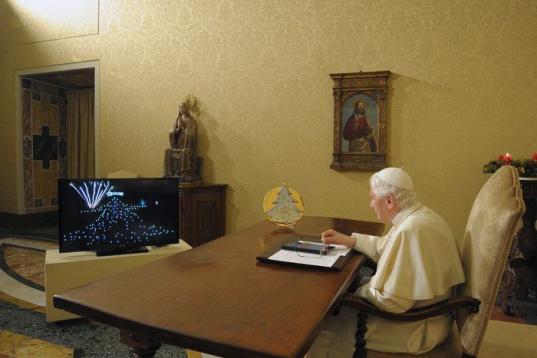 In this photo released by the Vatican newspaper Osservatore Romano, Pope Benedict XVI, seated in his studio at the Vatican City, uses an iPad device to light up one of the world's largest electronic Christmas tree in Gubbio, central Italy, Wedne...