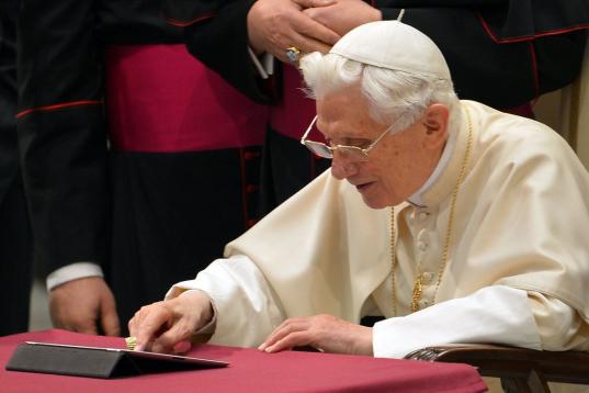 Pope Benedict XVI clicks on a tablet to send his first twitter message during his weekly general audience on December 12, 2012 at the Paul VI hall at the Vatican. Pope Benedict XVI sent his first Twitter message from a digital tablet on Wednesda...