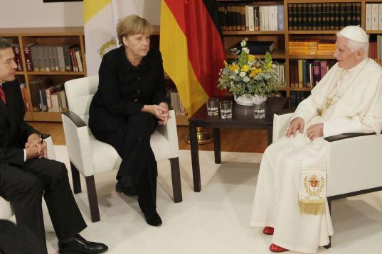 Benedict XVI speaks with German Chancellor Angela Merkel, center, and her husband Joachim Sauer, left, in the house of the German Bishops Conference in Berlin, Thursday, Sept. 22, 2011. Pope Benedict XVI is on a four-day official visit to his ho...